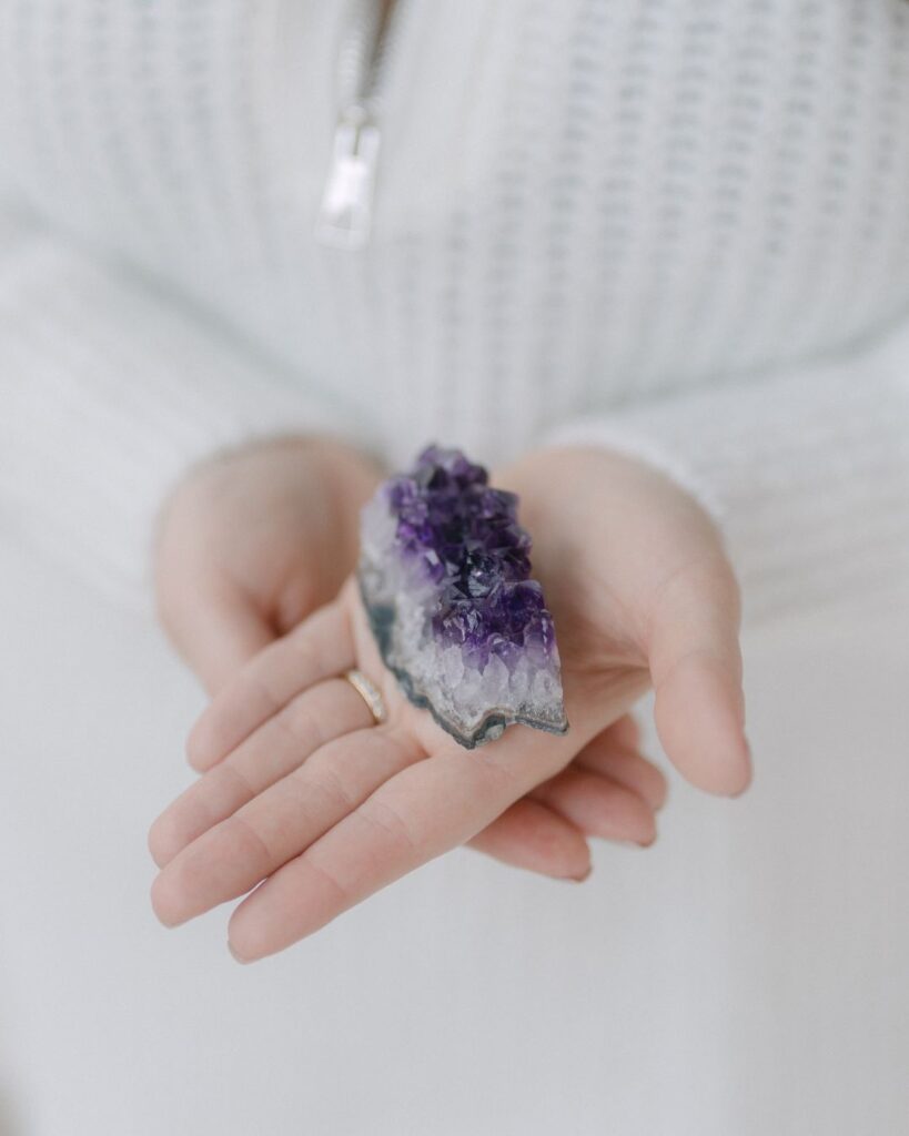 Amethyst-Kristall wird in Annas Hand präsentiert – Nahaufnahme